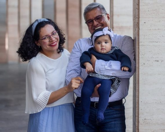 a man and a woman holding a baby in their arms